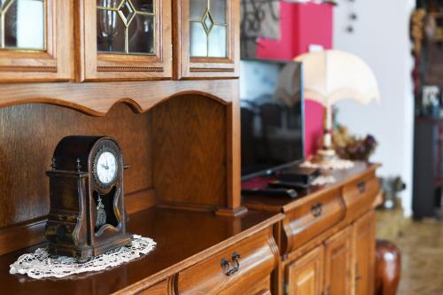 a clock sitting on top of a dresser with a tv at Villa Terrazza in Donji Morinj