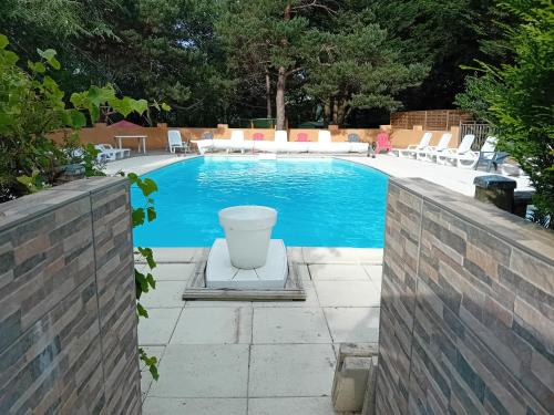 a swimming pool in a backyard with chairs and tables at Chalet dans camping à Camon in Camon