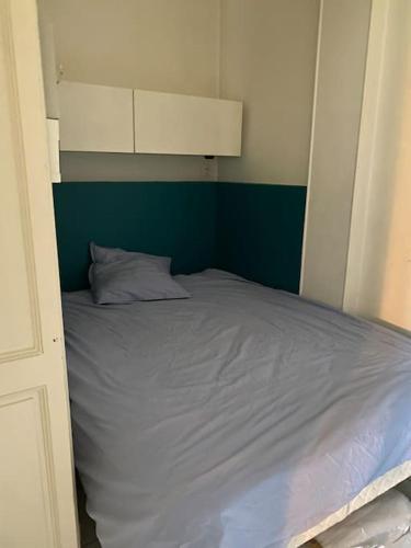 Ce lit se trouve dans une petite chambre dotée d'un mur vert. dans l'établissement Splendide Haussmannien dans hôtel particulier, à Bordeaux