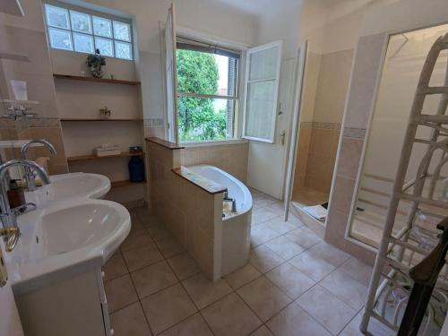une salle de bain avec deux lavabos, une baignoire et une douche dans l'établissement Oasis de sérénité avec vue mer imprenable, à Cagnes-sur-Mer