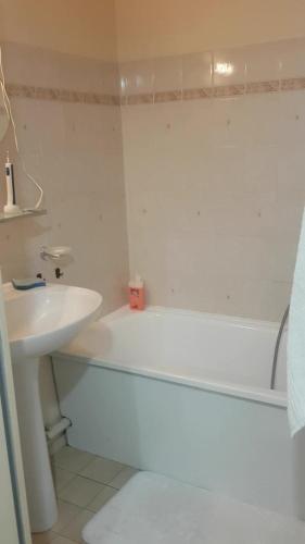 une salle de bain avec une baignoire blanche et un lavabo dans l'établissement T2 aux portes du vieux Fréjus et 5 mn de la plage, à Fréjus