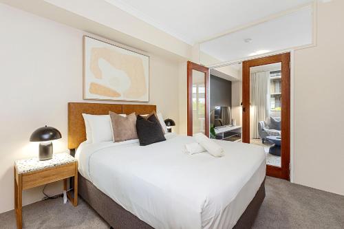 a bedroom with a large white bed and a table at 1BR Stylish Suite on Hay St in Perth