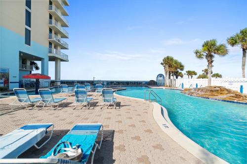 a pool at a resort with chairs and a swimming pool at Majestic Beach Resort Tower I by Panhandle Getaways in Panama City Beach