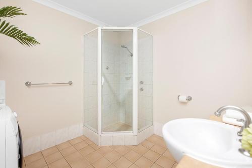 a white bathroom with a shower and a sink at 1BR Stylish Suite on Hay St in Perth