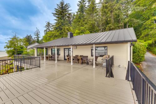 a large deck with a house with a roof at Beachfront Anderson Island Escape Rainier Views! in Beachcrest