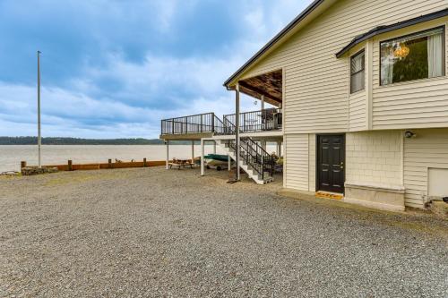 a house with a dock next to a body of water at Beachfront Anderson Island Escape Rainier Views! in Beachcrest