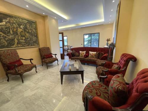 a living room with couches and chairs and a table at Batroun Green Serenity 2 BED - 24hr Electricity in Batroûn