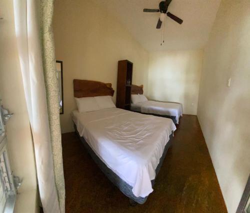 a bedroom with two beds and a ceiling fan at Casa Piedra de Agua Bacalar in Bacalar