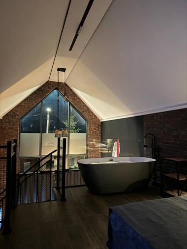 bañera grande en una habitación con ventana en Loft Tsaghkadzor, en Tsaghkadzor