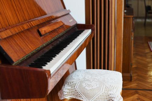 a wooden piano sitting next to a chair at Villa Terrazza in Donji Morinj