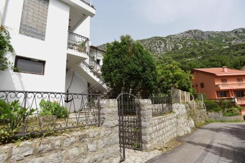 a house with a stone fence next to a street at Villa Terrazza in Donji Morinj