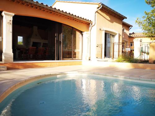 une piscine devant une maison dans l'établissement La Colline, villa avec piscine, à Châteaurenard