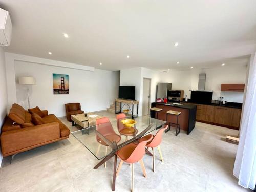 un salon avec un canapé, une table et des chaises dans l'établissement Villa Paquerette avec spa, à Nîmes