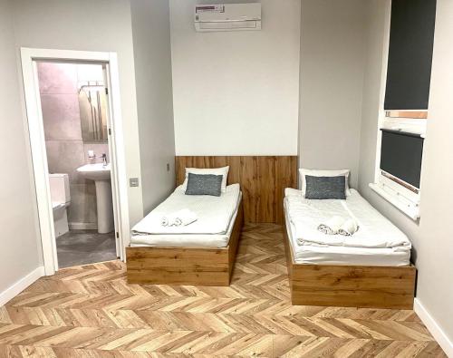 a small room with two beds and a mirror at Mastersclub in Ternopilʼ