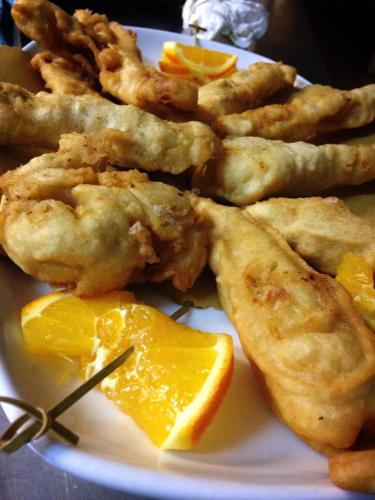 a plate of food with chicken wings and an orange slice at Hotel Pineta Ristorante country house in Fabriano in Campodonico