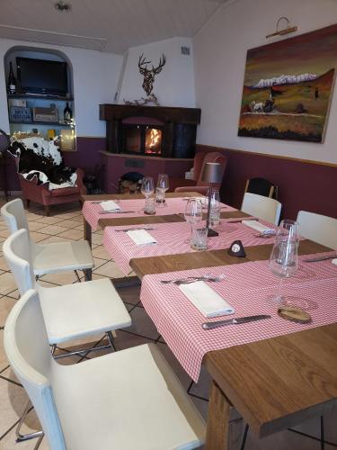 a dining room with tables and chairs and a fireplace at Hotel Pineta Ristorante country house in Fabriano in Campodonico