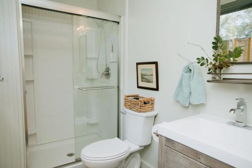 Un baño con ducha, inodoro y lavabo. en Cottage by the Sea: Pagnotto Shellback House, en Oak Island