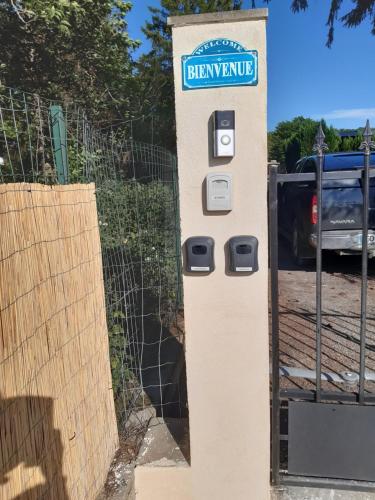 a sign for a dispenser in front of a fence at Studio au bord de l'étang in Laives