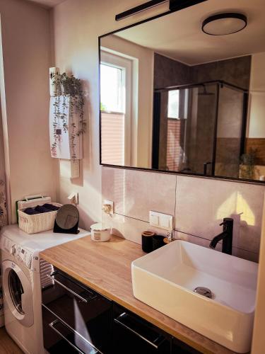a bathroom with a sink and a washing machine at Domek u Gajka Słajszewo in Słajszewo