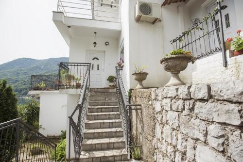 a stairway leading up to a white building with potted plants at Villa Terrazza in Donji Morinj