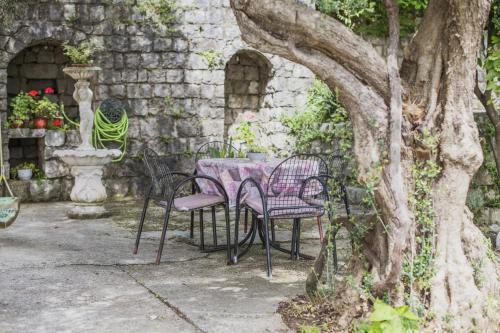 a table and chairs sitting under a tree at Villa Terrazza in Donji Morinj