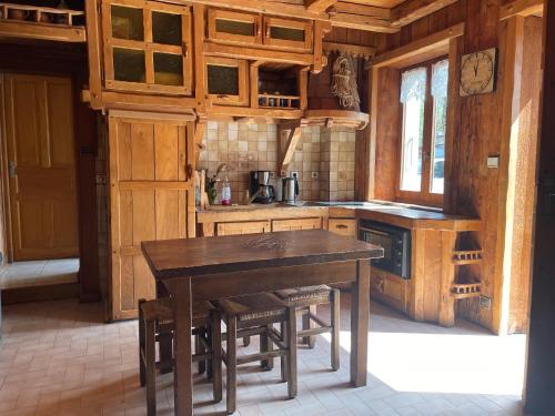 - une cuisine en bois avec une table et des chaises en bois dans l'établissement Location Le Ruan, à Morillon