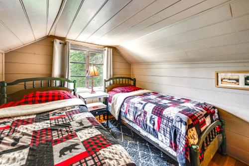 two beds in a room with wooden walls at Salisbury Cottage about 7 Mi to High Rock Lake! in Salisbury