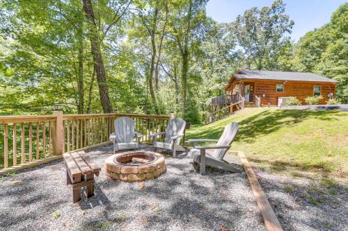 a backyard with chairs and a fire pit and a log cabin at Private Hot Tub and EV Charger Cozy Murphy Cabin! in Murphy