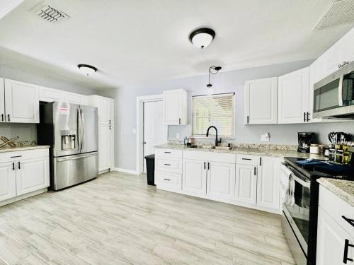 a kitchen with white cabinets and stainless steel appliances at Game Night Ready Lakeland Stay Near Colleges in Lakeland