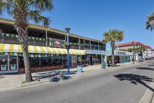 a street with palm trees in front of a building at Sandpiper #108 in Tybee Island