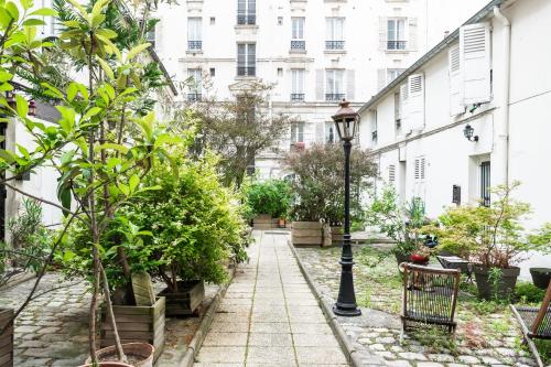 une cour avec des plantes et un lampadaire dans l'établissement Appartement Térreo - Welkeys, à Paris