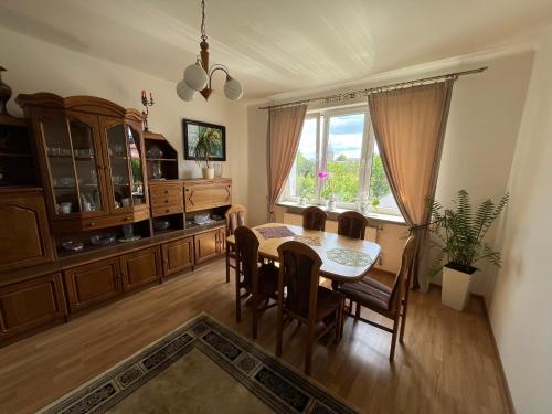 a dining room with a table and chairs and a window at Apartament z ogrodem Harcerska 4 in Zamość