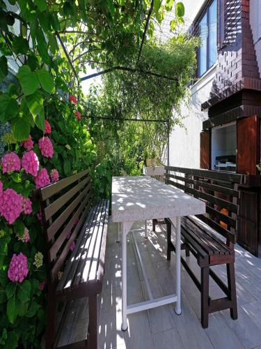 a table and two benches on a patio with flowers at Penthouse Stella in Pula