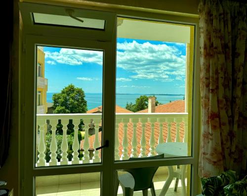 a door to a balcony with a view of the ocean at Aqua Studio - Sveti Vlas in Sveti Vlas