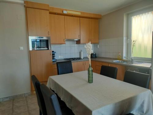 a kitchen with a table with a vase of flowers on it at Wellness Park Apartman in Dunaszentmiklós