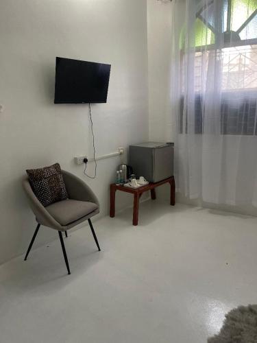a living room with a chair and a television at Nashu House Stone Town in Ngambo