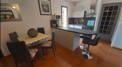 - une cuisine avec une table, une table et des chaises dans l'établissement St Cyr sur mer appart 6pers avec jardin et parking A 30m de la plage, à Saint-Cyr-sur-Mer