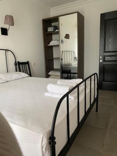 a bedroom with a bed with white sheets and a mirror at Gonio Beach Apartment in Batumi