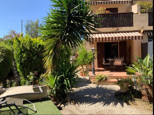 une maison avec un palmier et une terrasse dans l'établissement St Cyr sur mer appart 6pers avec jardin et parking A 30m de la plage, à Saint-Cyr-sur-Mer