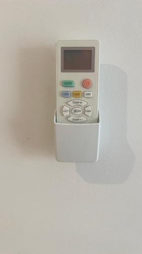 a remote control sitting inside of a white container at Apartamento T2 equipado Vila Verde in Santa Maria