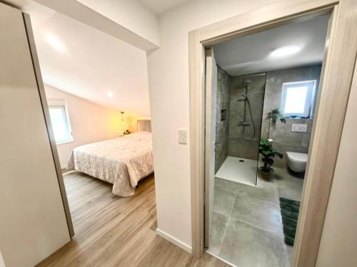 a bedroom with a bed and a bathroom with a shower at Green View Apartment in Vrh