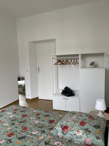 une chambre avec un lit avec un couvre-lit fleuri dans l'établissement T2 Alfortville, à Alfortville