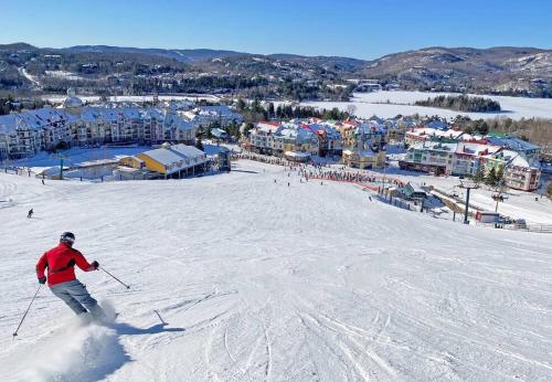 a person is skiing down a snow covered slope at Tremblant Chalet Walking Distance from Activities in Mont-Tremblant