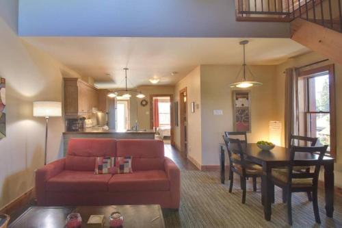 a living room with a red couch and a table at Tremblant Chalet Walking Distance from Activities in Mont-Tremblant