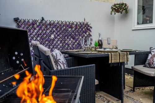 - un salon avec une cheminée, une table et des chaises dans l'établissement Shorethwaite, à Amble