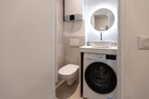 een badkamer met een toilet, een wastafel en een spiegel bij Joli studio proche de paris -pantin in Pantin