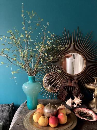 une table avec une assiette de fruits et un vase bleu dans l'établissement Maison avec jardin, à Paris