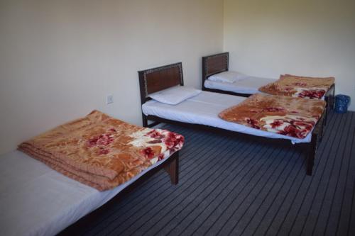 two beds in a room with at Yak Sarai Hotel & Restaurant in Skardu