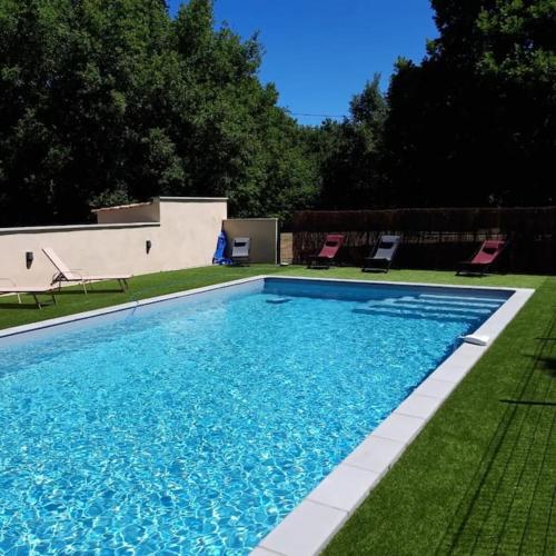 une grande piscine avec des chaises dans une cour dans l'établissement LAMIELLE grande maison restaurée aux portes du Quercy, à Moissac