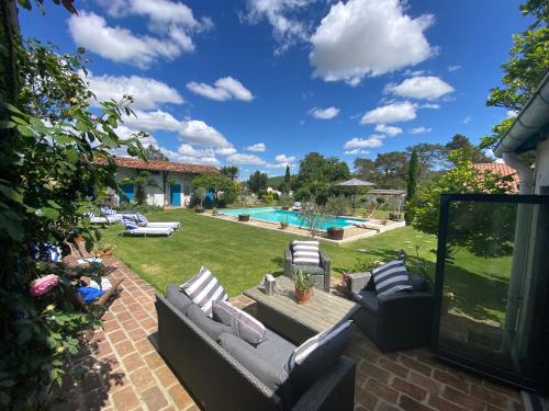 une terrasse avec des canapés et une piscine dans l'établissement Domaine Du Tafiart, à Sarron